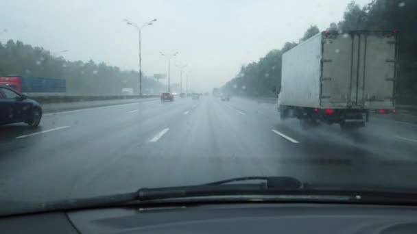 Man's hand drives a car on a rainy day in a heavy traffic, first-person view — Stock Video