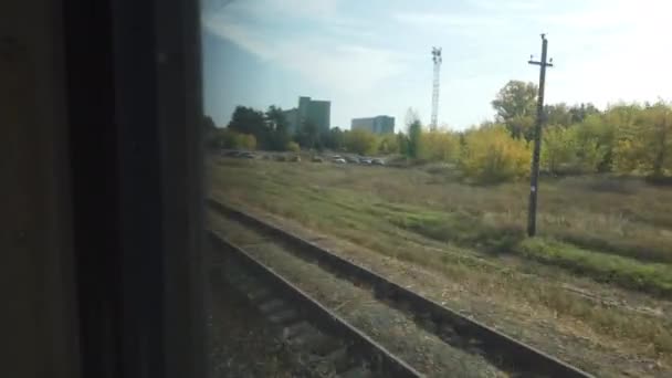 Vista desde la ventana de un tren de pasajeros hasta el asentamiento, enfoque selectivo — Vídeos de Stock