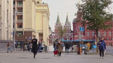 Farklı yaşlarda insanlar salgın sırasında büyük bir şehrin sokaklarında yürürler.
