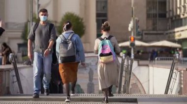 Sırt çantalı ve koruyucu maskeli bir adam.