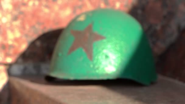 Ein grüner Helm mit rotem Stern aus dem Zweiten Weltkrieg am Denkmal — Stockvideo