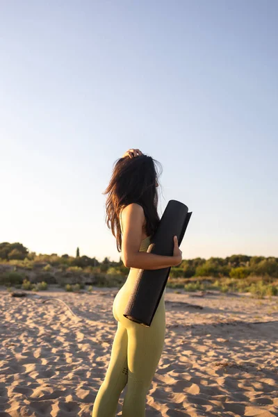 Gün batımında sahilde yoga yapan genç bir kadın. Akdeniz 'de egzersiz yapan bir kızın stok fotoğrafı..