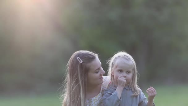 Jong gelukkig moeder en dochter genieten in het park — Stockvideo