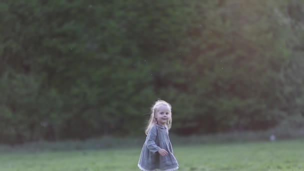 Uma menina loira correndo em câmera lenta em cinza, câmera lenta — Vídeo de Stock