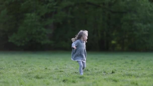 Una ragazzina bionda che corre al rallentatore in grigio, al rallentatore — Video Stock