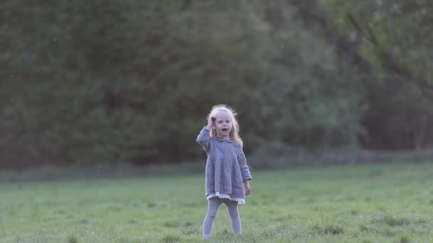 Una pequeña rubia corriendo en cámara lenta en gris, cámara lenta — Vídeo de stock