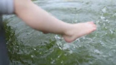 Kızlar oturur ve ayaklarını suda sallar..