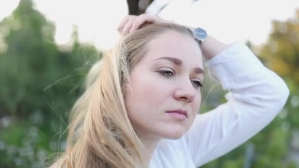 Stylowo ubrana blondynka kobieta dobrze się bawiąca Odkryty dotyk włosów w zwolnionym tempie — Wideo stockowe