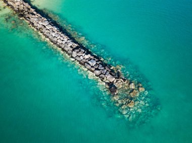 Pililaau Beach Park'Pokai Körfezi'ndeki Açık Turkuaz sularında Oahu, Hawaii'nın batı kıyısında jeti yukarıda kayalık sahil dalga ara.