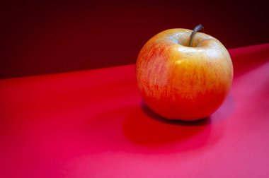 Kırmızı arkaplanda kırmızı elma. 