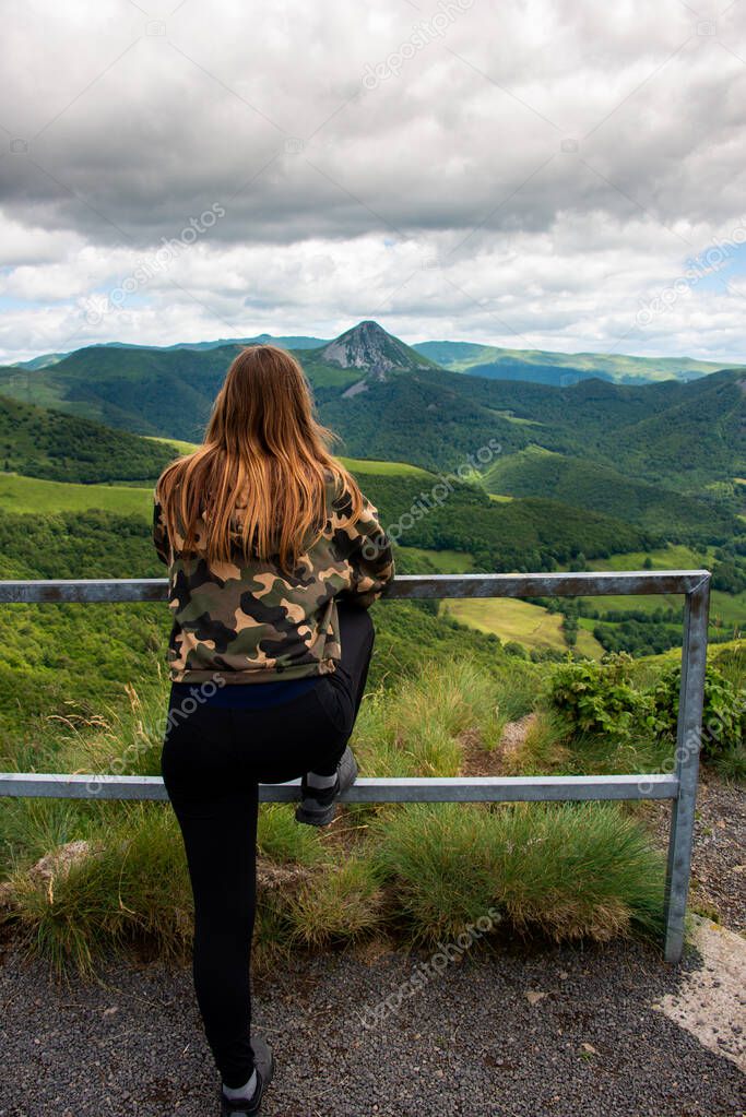 young woman stretching looking at the view of old volcanos, adventure holidays, auvergne ,France .