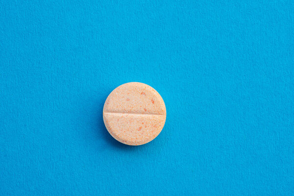 Vitamin C tablets on blue background ,winter protection from colds and flu ,food supplement .