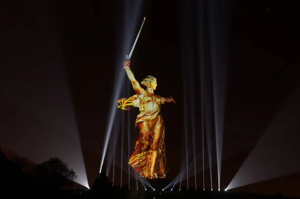 Sculpture the Motherland on Mamayev Kurgan in gold light during the show Light of the Great Victory 2018 of year