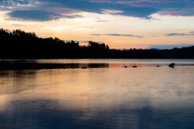 New Hampshire 'daki Squam Gölü' nde güneşin doğuşu uzun sürdü.