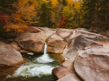 Kancamagus otoyolunun yakınındaki Franconia Falls 'un insansız hava aracı görüntüsü New Hampshire' da sonbaharda tam çiçekleniyor.