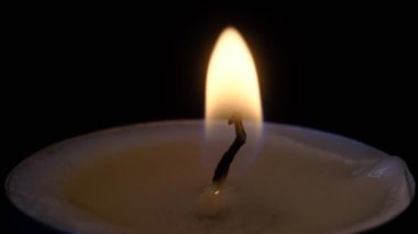 Küçük mumlar yanıyor. Ağır çekimde yaklaşın. Karanlıkta mum alevleri..