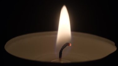 Küçük mumlar yanıyor. Ağır çekimde yaklaşın. Karanlıkta mum alevleri..