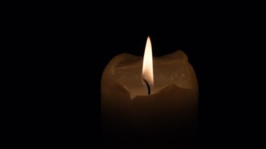 Küçük mumlar yanıyor. Ağır çekimde yaklaşın. Karanlıkta mum alevleri..