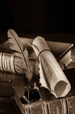 Quill'in kalem ve eski kitaplar, sepya etkisi ile ahşap bir masa bir haddelenmiş papirüs sayfada