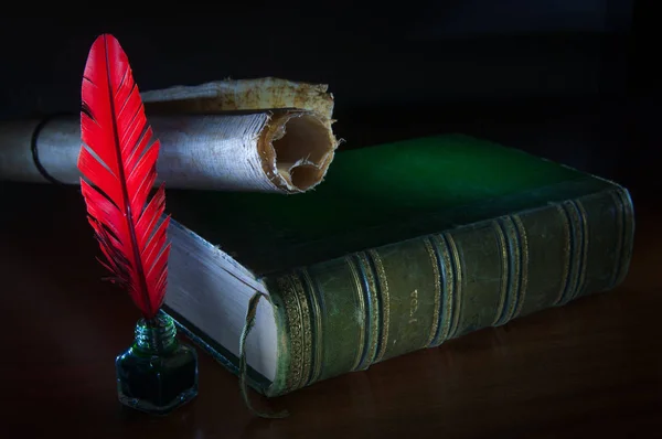 红色的羽毛笔和一张在木桌上用旧书卷纸 — 图库照片