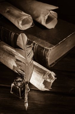 Quill'in kalem ve eski kitaplar, sepya etkisi ile ahşap bir masa bir haddelenmiş papirüs sayfada