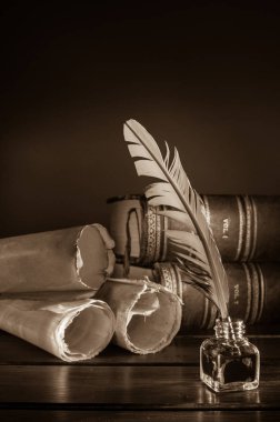 Quill'in kalem ve eski kitaplar, sepya etkisi ile ahşap bir masa bir haddelenmiş papirüs sayfada
