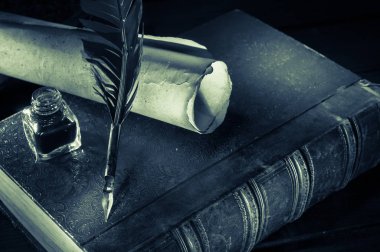 Quill'in kalem ve eski kitaplar, siyah beyaz etkisi ile ahşap bir masa bir haddelenmiş papirüs sayfada