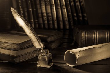 Quill'in kalem ve eski kitaplar, sepya etkisi ile ahşap bir masa bir haddelenmiş papirüs sayfada