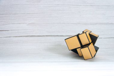 Ahşap bir masa arkasında Rubik küpü.