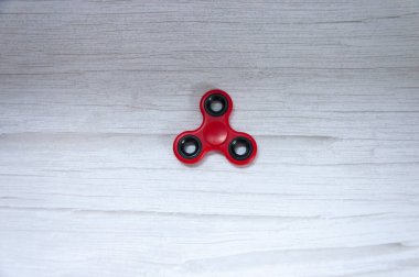 Gri ahşap masada kırmızı hareketli dönen alet izole edildi..