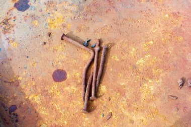 Metal zeminde paslı çiviler.