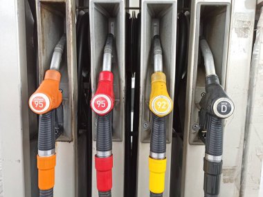 Moskova, Rusya. Ağustos 2020. Benzin istasyonundaki yakıt deposunda farklı renklerde yakıt tabancaları ya da yakıt silahlarının fotokopisi var. Yakıt silahları yuvalara yerleştirildi