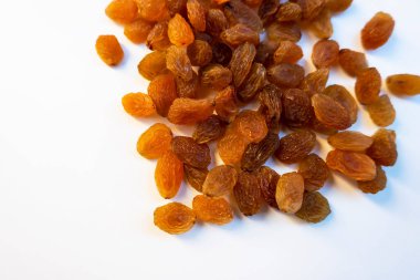 Beyaz arka planda çekirdeksiz kuru üzümlü yakın çekim.