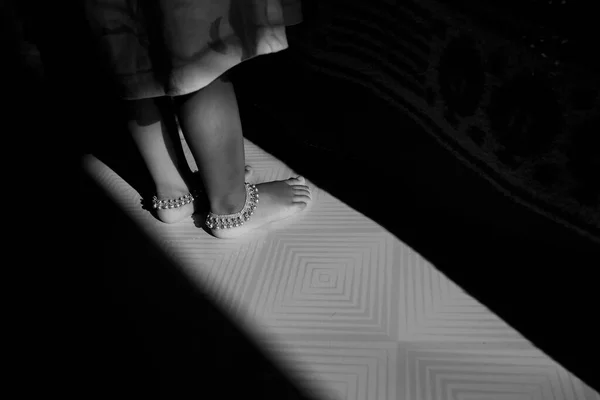 Een Meisje Kind Benen Enkelband Ketting Geïsoleerd Vloer — Stockfoto