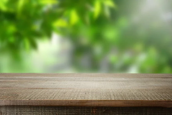 Wooden empty and blur green forest background.