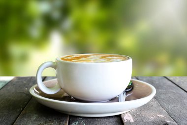 Ahşap masa üzerinde kahve fincanı ve bulanıklık arka plan.