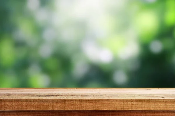 木製の机とぼかし緑の背景 — ストック写真