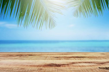 Palmiye ağacı ve ahşap masa ile plaj arka plan.