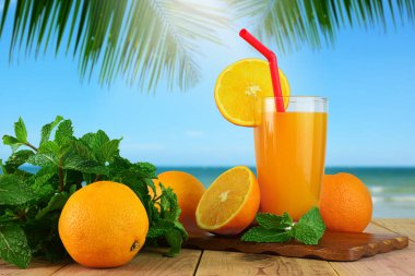 Portakal ve bulanık plaj arka plan ile taze portakal suyu.