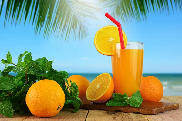 Portakal ve bulanık plaj arka plan ile taze portakal suyu.
