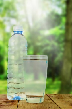Bulanık doğa arka plan ile su ve su şişesi cam.
