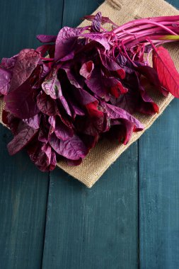 Ahşap masada kırmızı ıspanak.