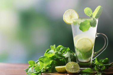 Taze limon suyu veya limon suyu, limon dilimi ve nane masada.