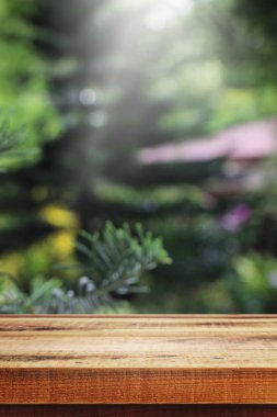 Tahta masa ve bulanık bahçe arka planı.