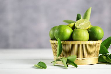 Beyaz ahşap arka planda taze limon. Yeşil kireçler.