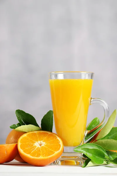 Ahşap masada portakal meyve ile portakal suyu Cam.