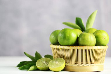 Beyaz ahşap arka planda taze limon. Yeşil kireçler.