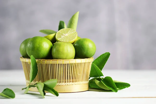 Fresh limes on white wooden background. Green limes.