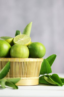 Beyaz ahşap arka planda taze limon. Yeşil kireçler.