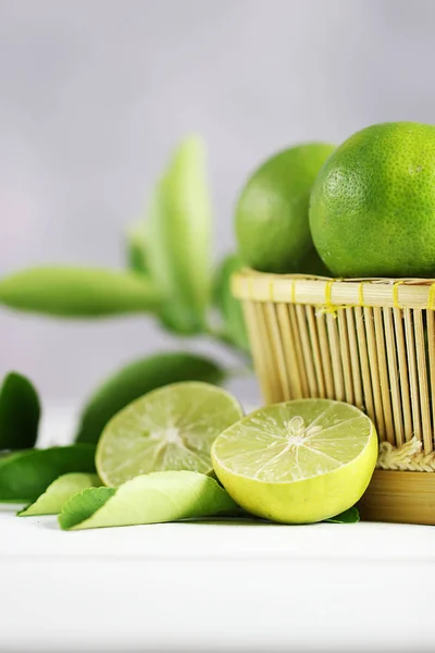 Beyaz ahşap arka planda taze limon. Yeşil kireçler.